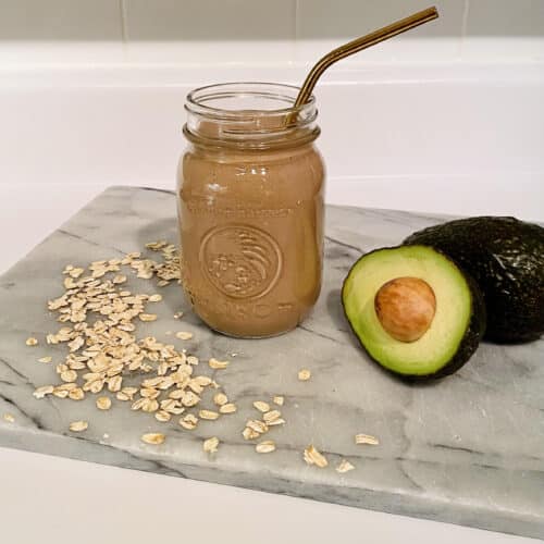 Brown Smoothie in Mason Jar Surrounded by Avocado and Oats