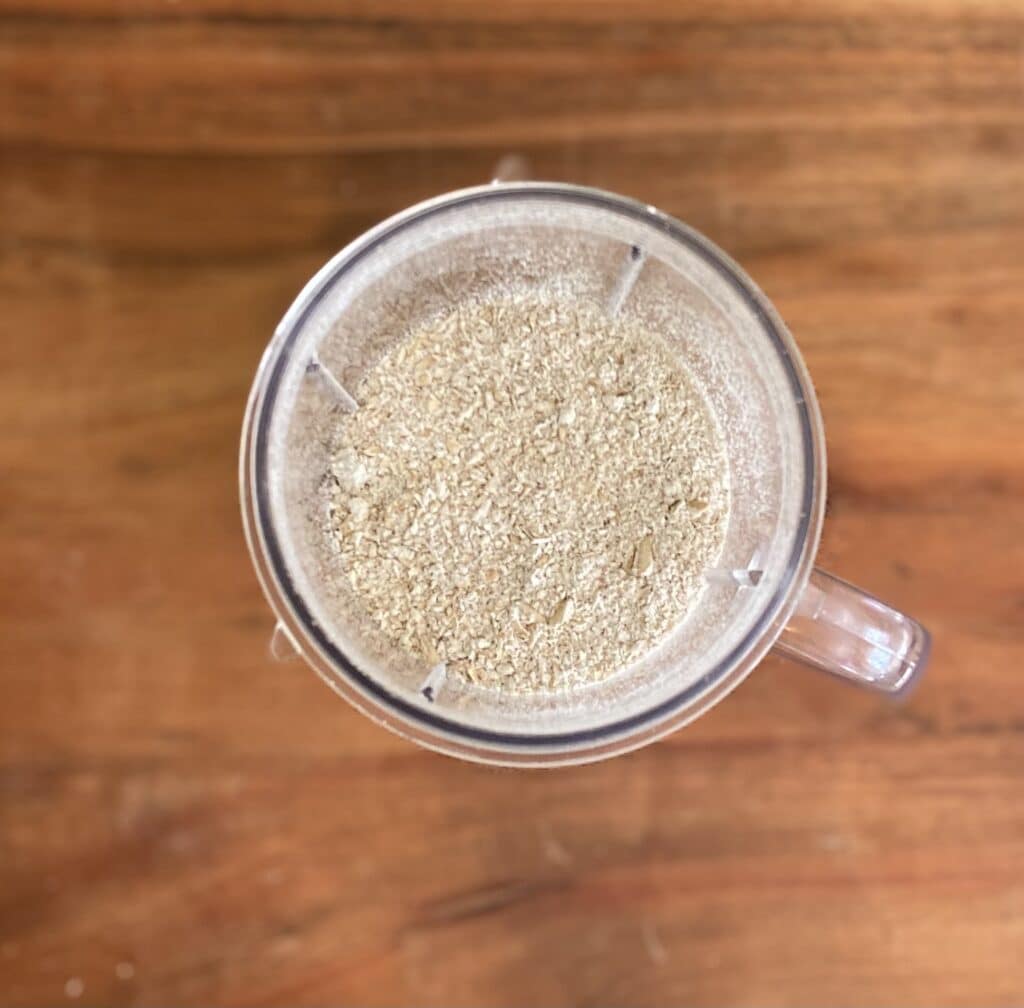 The top of a blender with the milk and oats, before they are combined.