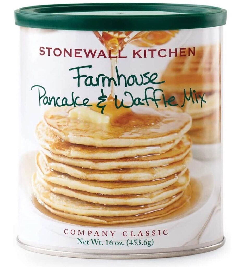 A cannister of Stonewall Kitchen farmhouse pancake and waffle mix. The jar has a stack of pancakes topped with maple syrup on the cover. 