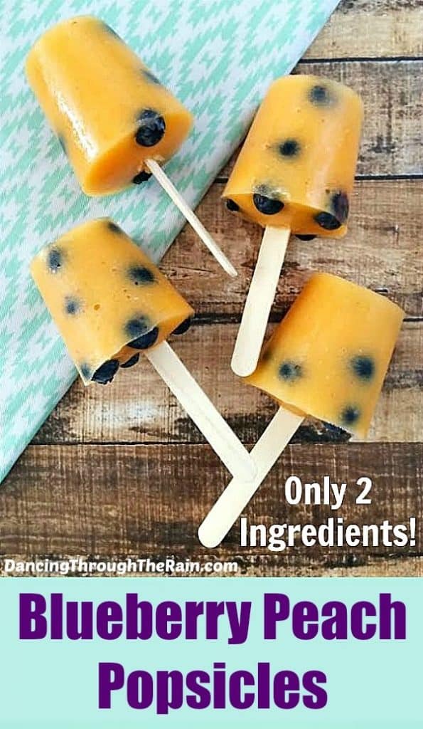 A low cholesterol dessert of four orange popsicles with blueberries on a wood table.