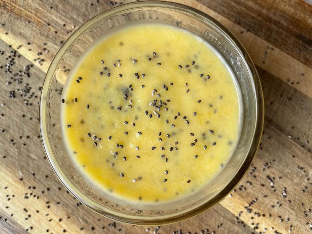 Homemade juice to lower cholesterol pictured from above in a glass atop a wooden countertop.