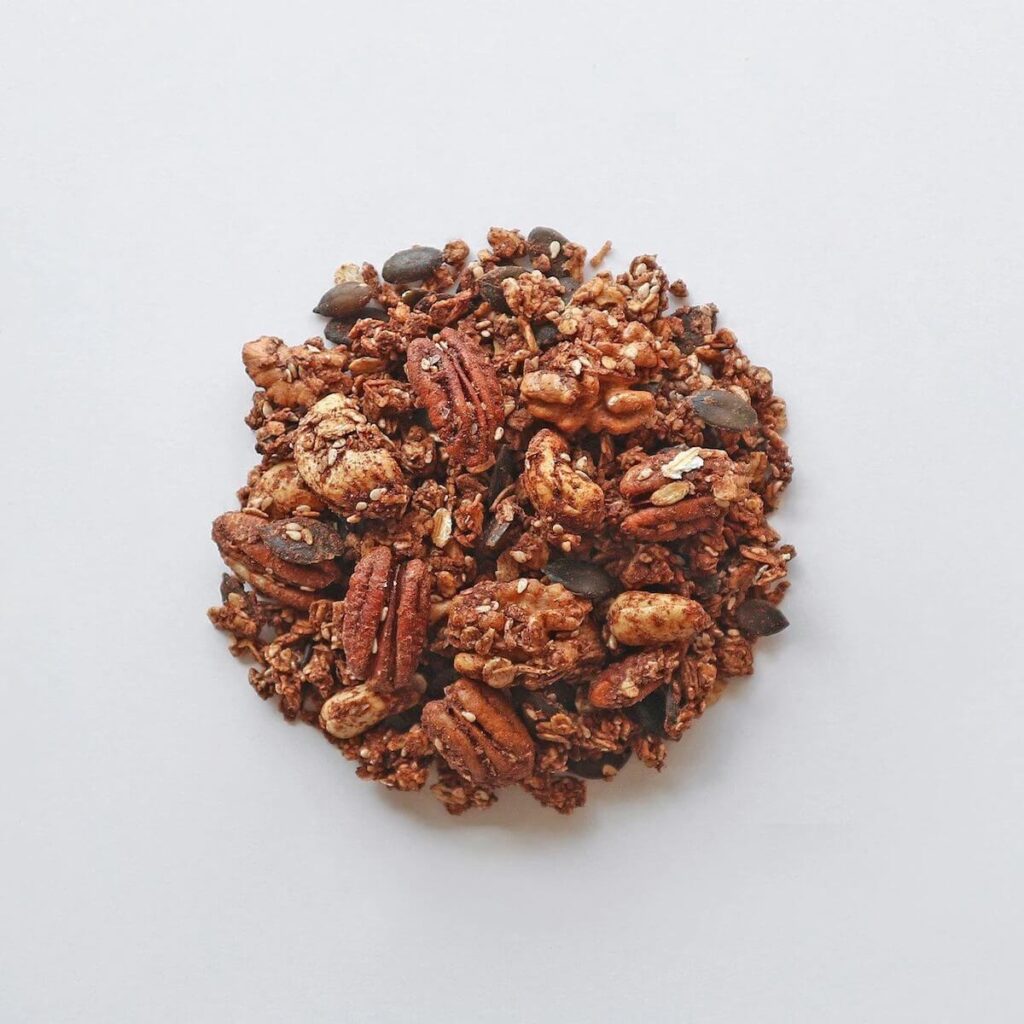 Am image of a circular cluster of maple pumpkin spice granola. Includes cashews, almonds, pecans, and pumpkin seeds.