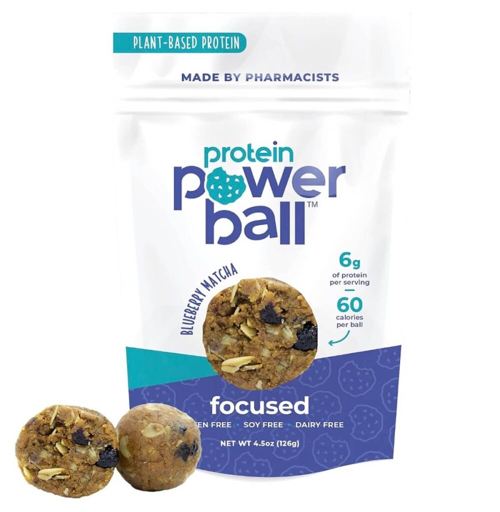 Blueberry matcha protein power balls package. There are two protein power balls next to the bag.