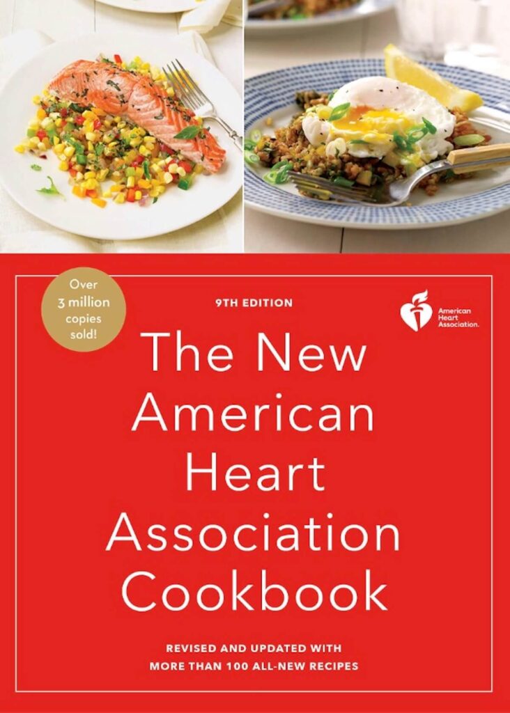 A cookbook with an image of salmon, and one with egg. The title reads "the new American Heart Association cookbook". 