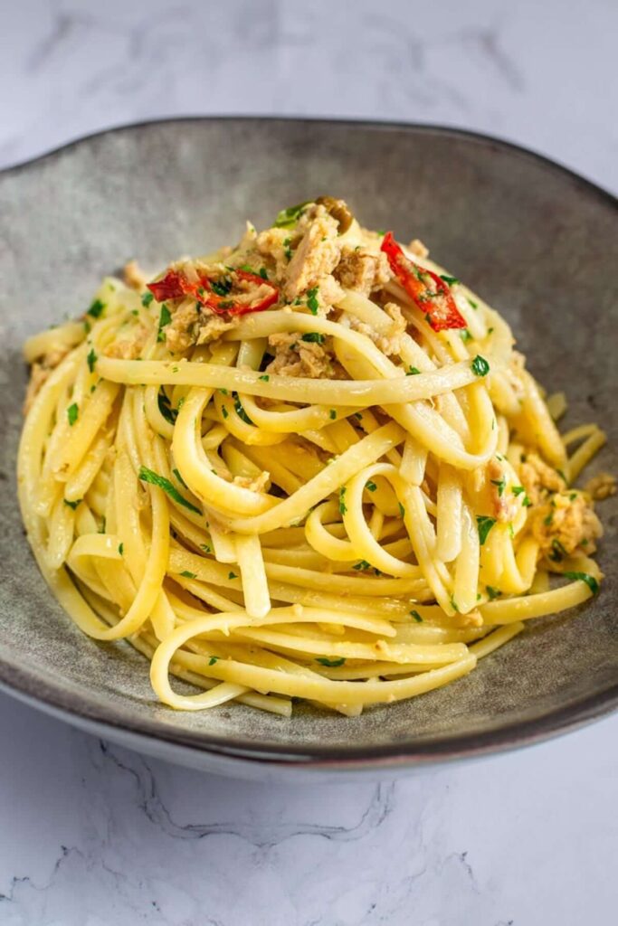 Tuna pasta pictured in a grey dish on a granite countertop. 