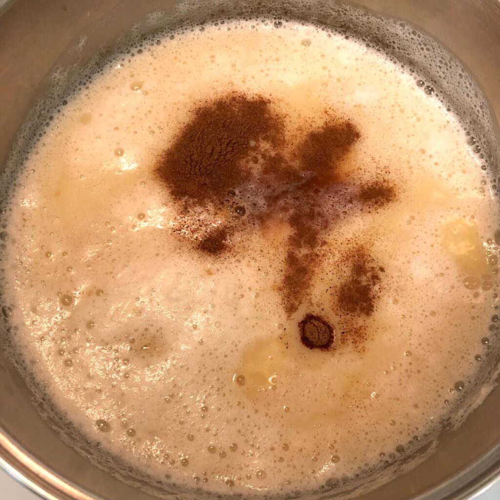 Chickpea milk in a pot with added nutmeg and cinnamon. 