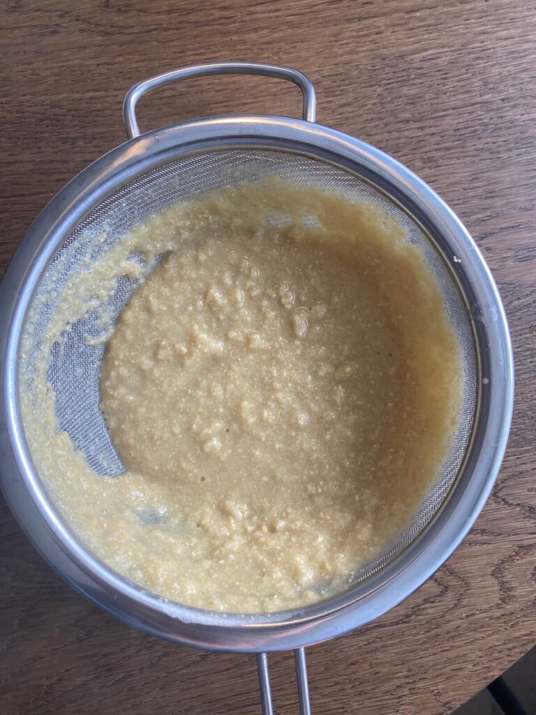chickpea milk strained using a fine mesh sieve overtop of a bowl. 